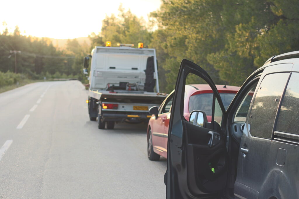 Car Breakdown With Towing Vehicle On Roadside And Warning Triangles