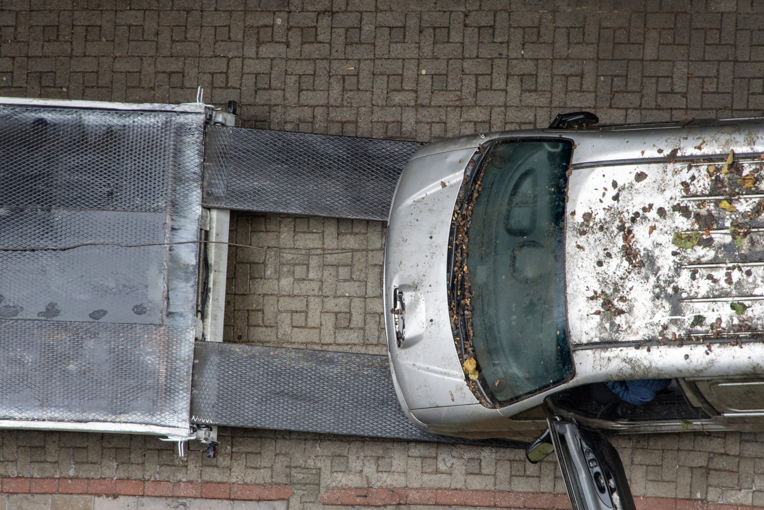 An Old, Inoperable, Abandoned Vehicle Is Being Towed Away By A Tow Truck