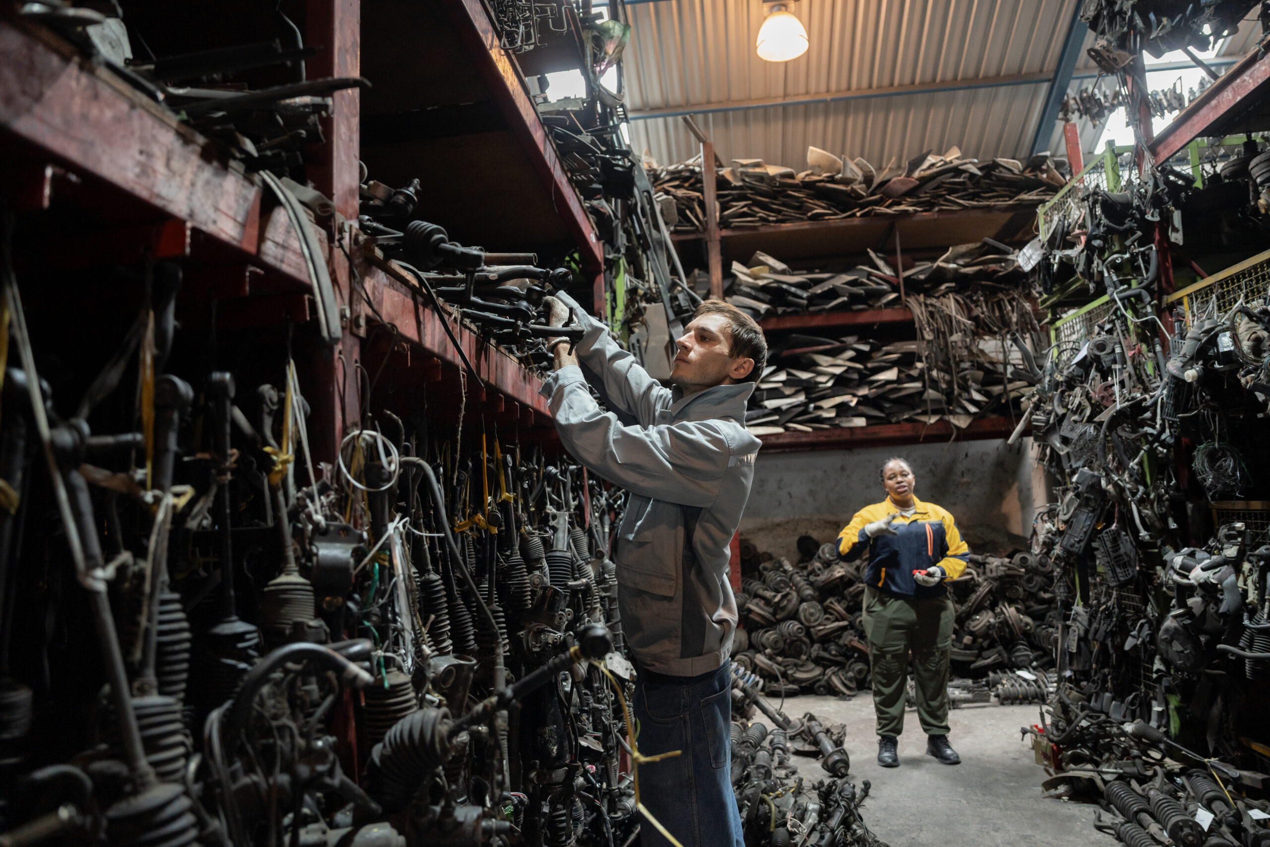 African American And Caucasian Technician Or Engineer Checking Car Part With Car Part Background